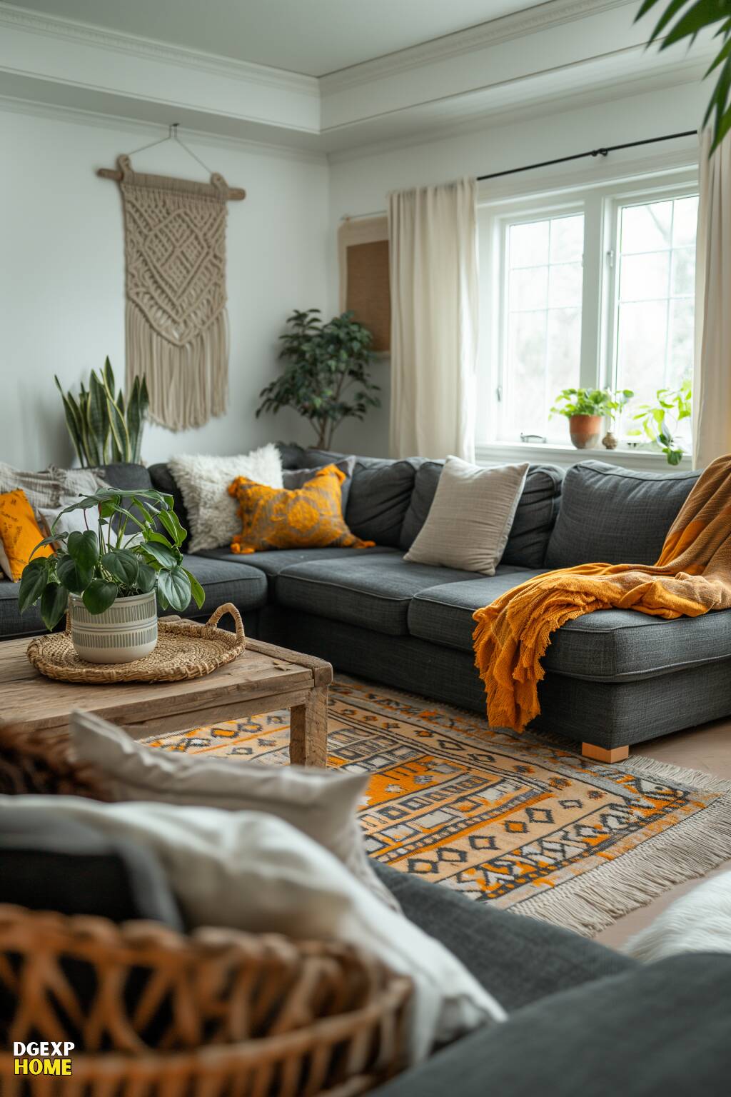 Modernes Boho-Wohnzimmer mit einem anthrazitfarbenen Sektionssofa, gelben Wurfkissen, einem gewebten Teppich und Makramee-Wanddekoration.